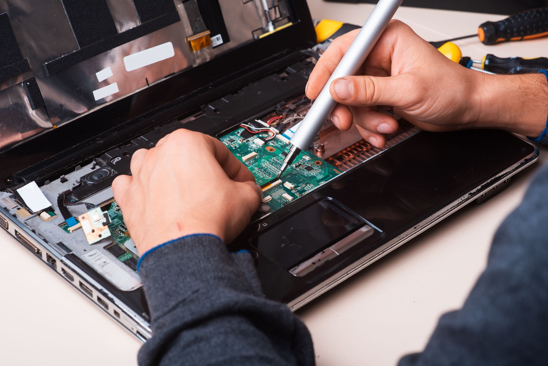 Wizard repairs laptop with tools and hands